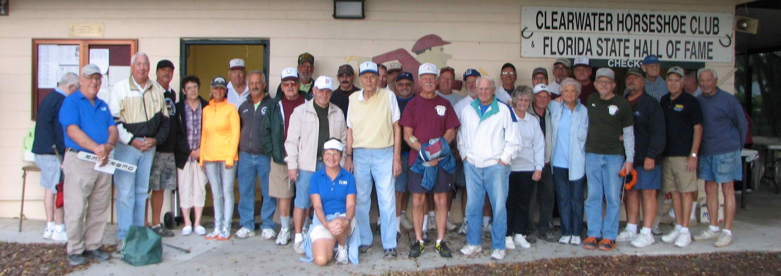 Club members gathered outside the clubhouse under the Clearwater Horseshoe Club and Florida State Hall of Fame sign