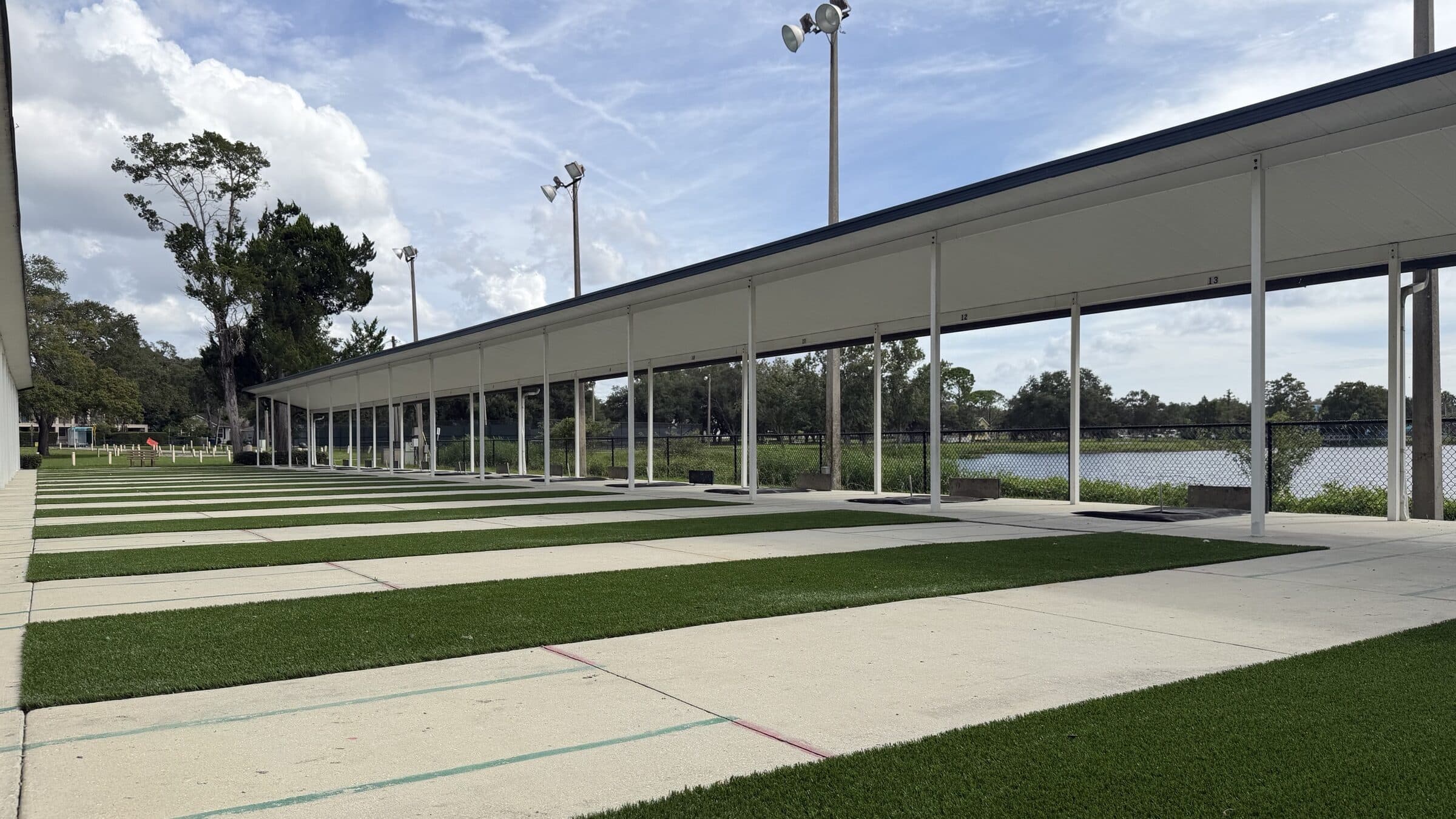 Empty horseshoe courts with green turf pitching strips beside the lake at Ed Wright Park