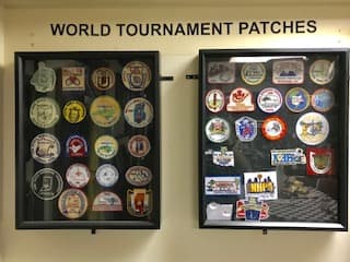 Two display cases holding decades of World Tournament patches